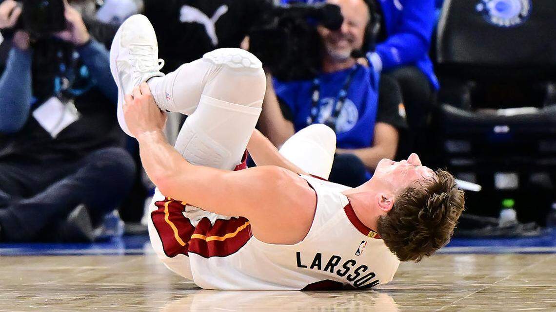 Pelle Larsson #9 of the Miami Heat holds his ankle after an injury in the first half of a Emirates NBA Cup Quarterfinals game against the Orlando Magic at Kia Center on December 09, 2025 in Orlando.