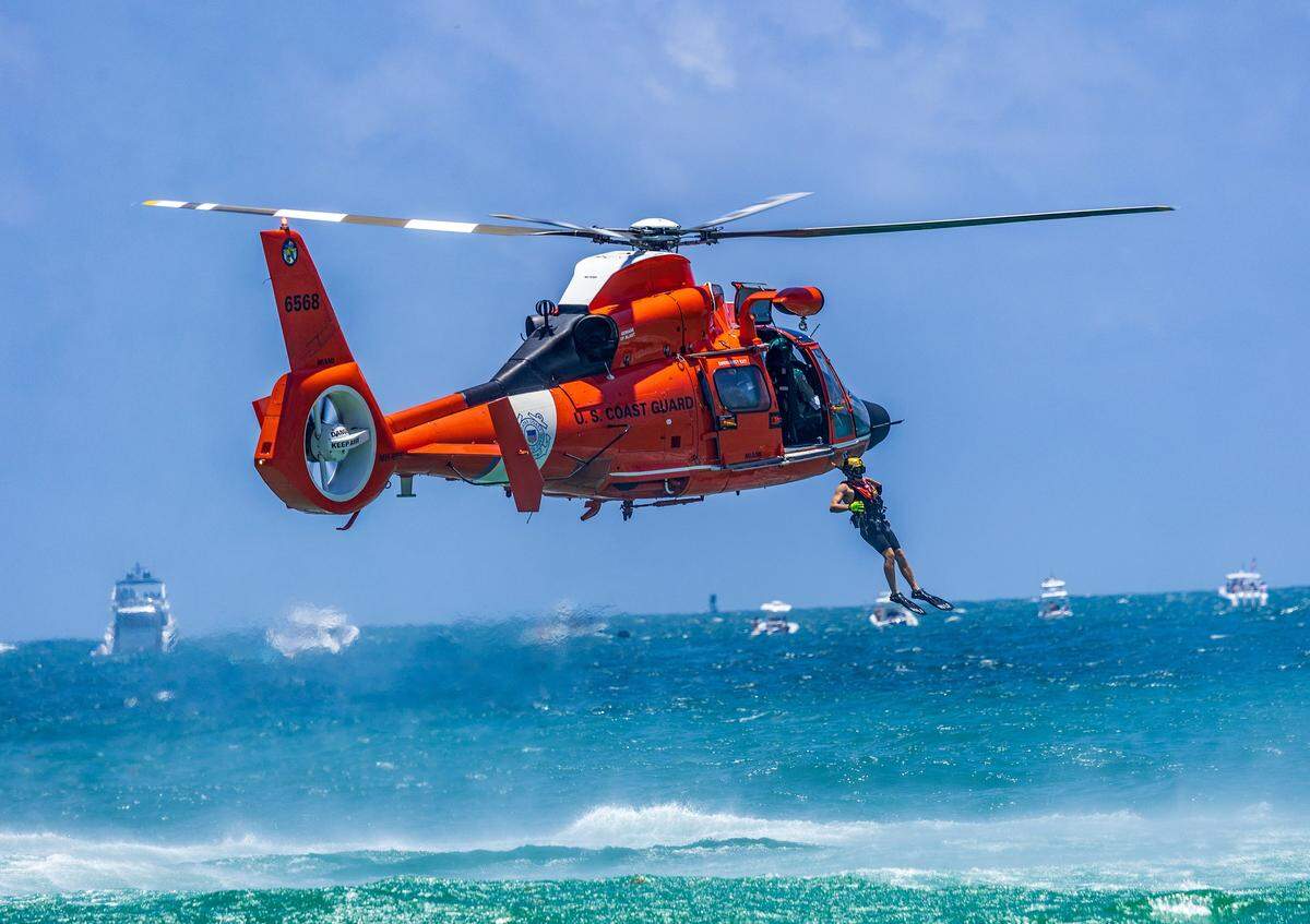 A United States Coast Guard Air Sea swimmer jumps to the ocean from a MH-65E Dolphin helicopter during a rescue demonstration in South Beach during the Hyundai Air & Sea Show annual National returns Salute to America's Heroes for Memorial Day Weekend celebration, in Miami Beach, on Saturday, May 23, 2026. 
