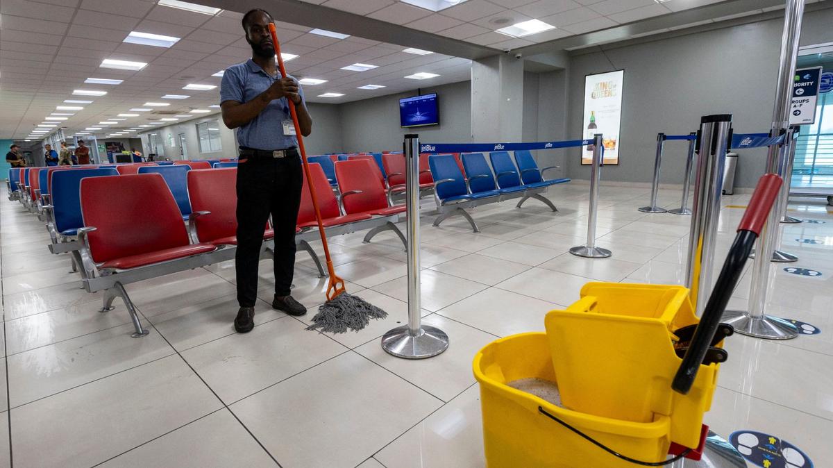 A Haitian airport worker pauses Wednesday, May 15, 2024 as he mops the floor in an empty main terminal at Toussaint Louverture International Airport in Port-au-Prince, Haiti. In November, the airport was shutdown for a second time because of armed gangs.