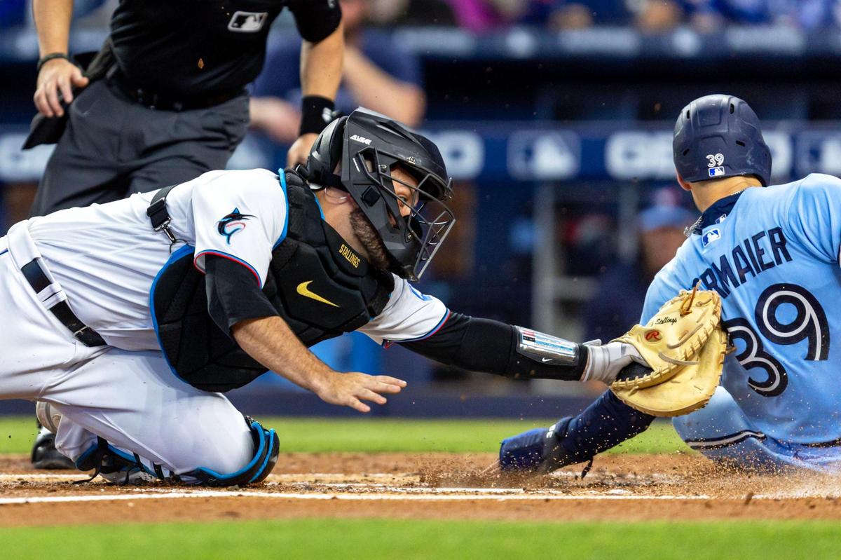 Miami Marlins catcher Jacob Stallings (58) attempts to tag Toronto Blue Jays base runner Kevin Kiermaier (39) as he scores the fourth run of the second inning of an MLB game at LoanDepot Park on Wednesday, June 21, 2023, in Miami, Florida.