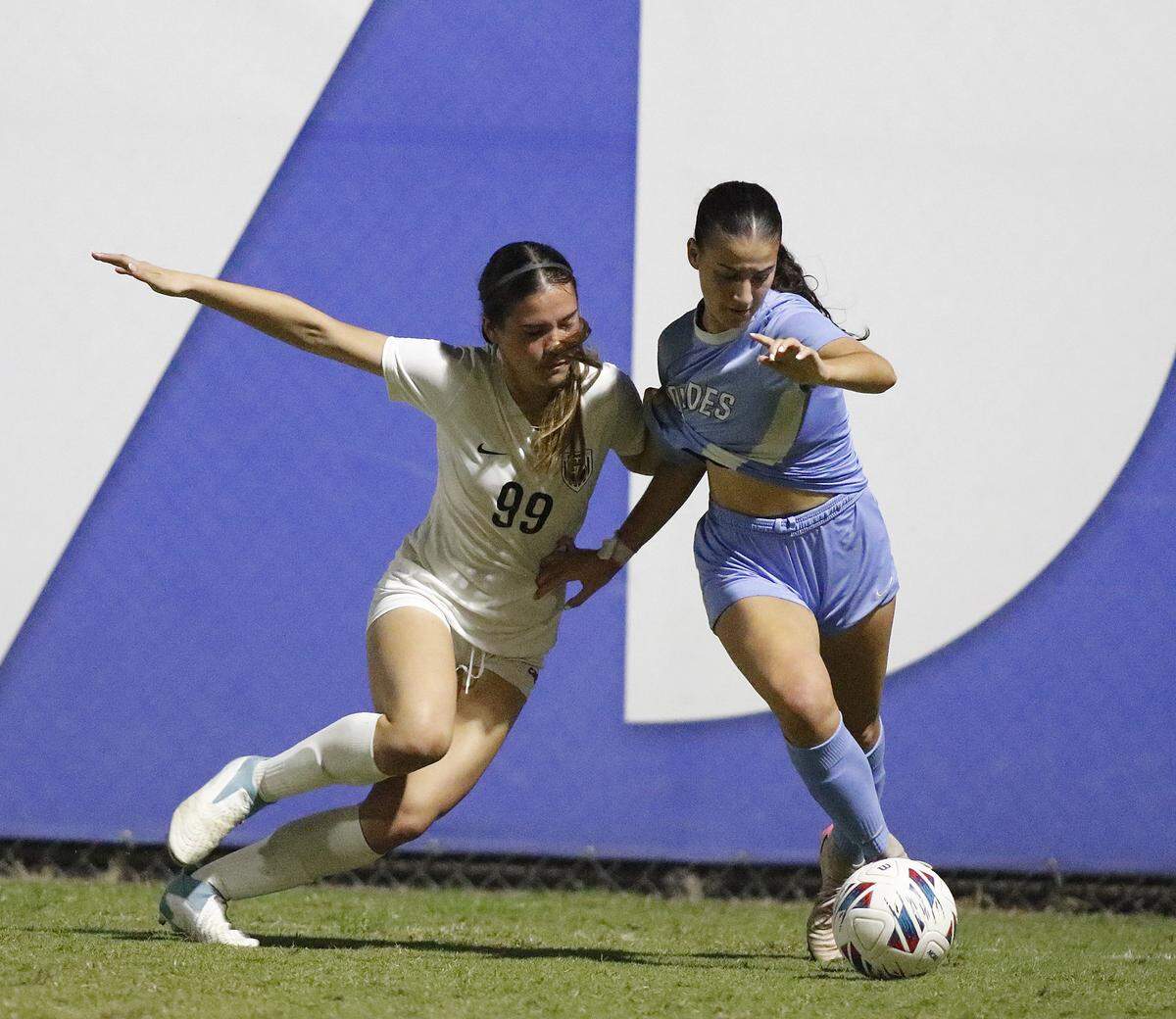 Pembroke Pines Charter’s Rileigh Sabel (99) and Lourdes Academy’s Lily Martinez battle for possession during the Region 4-5A final girls’ soccer match Tuesday, Feb. 17, 2026, at Miami-Dade College’s Kendall Campus.
