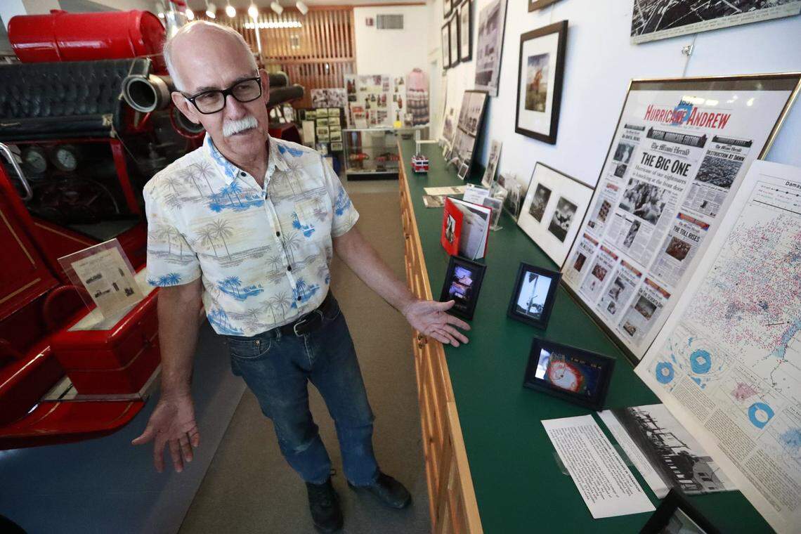 In this May 6, 2019, photo, Jeff Blakley shows off some of the photos and newspapers documenting the destruction to the town by Hurricane Andrew on display at the Historic Homestead Town Hall Museum in Homestead, Florida. Blakely remembers watching the exodus while pulling 12-hour shifts as a BellSouth lineman, repairing telephone lines for the ravaged area.