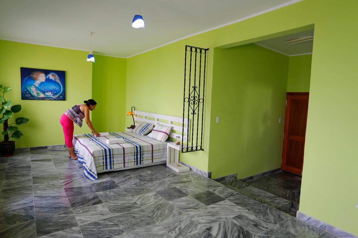 A worker prepares a room for rent at a private home in Havana.  New business regulations allow only one license per person and in some cases only one per home.