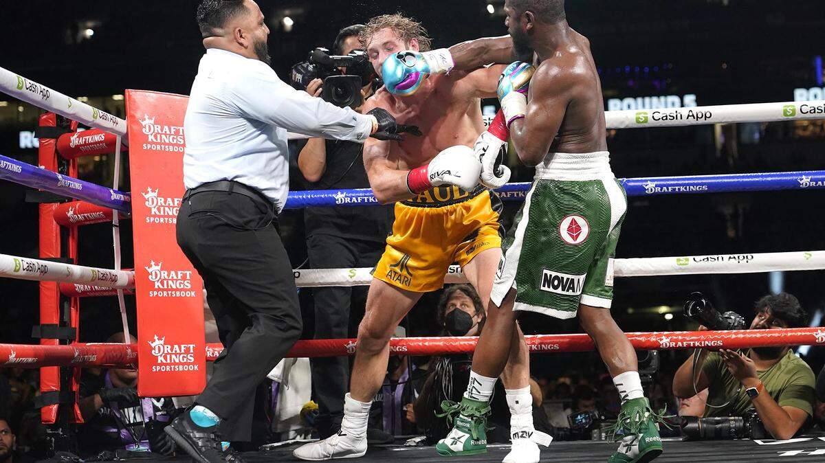 Logan Paul, left, and Floyd Mayweather, right, fight during an exhibition boxing match at Hard Rock Stadium, Sunday, June 6, 2021, in Miami Gardens, Fla.