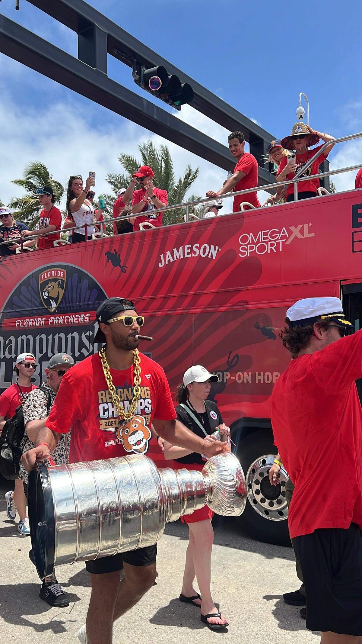 Panthers defenseman Seth Jones walks proudly past Elbo Room on A1A in Fort Lauderdale with cigar in mouth and Stanley Cup in hand.