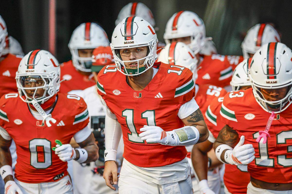 Miami Hurricanes quarterback Carson Beck (11) rushes the field with teammates before the NCAA football game against the Syracuse Orange at Hard Rock Stadium in Miami Gardens, Florida on Saturday, November 8, 2025.