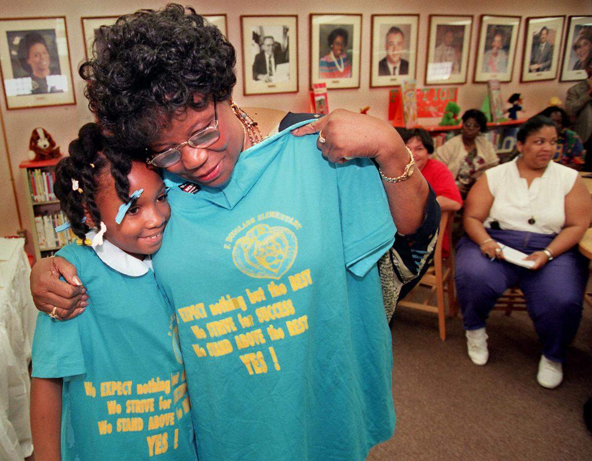 TO DADE by Carl Juste/mhs, Frederick Douglas Elementary, US Representative Carrie P. Meek had lunch with the students of Frederick Douglas Elementary, and then held a press conference to discuss the National School Lunch Act and cuts on other child-care programs. Betty Jackson,9, third grader, gets a huge from Carrie Meek after presenting her a t-shirt for her visit to Frederick Douglas Elementary. ( l to r)