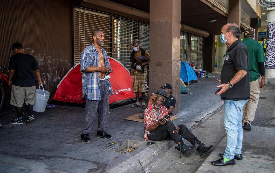 Ron L. Book, Chair of the Homeless Trust, tries to convince a group of homeless living on the sidewalk behind the former Macy’s store in downtown Miami, to get vaccinated with the (J&J/Janssen) COVID-19 vaccine.
