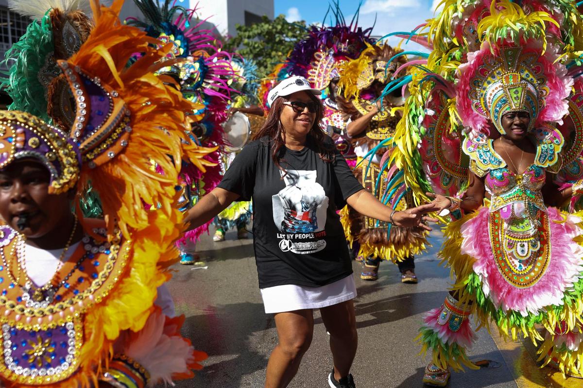 Valda McKinney, President of the A. Philip Randolph Institute Miami-Dade Chapter, dances with the Junkanoo band during a Souls to the Polls event outside of the Joseph Caleb Center on Sunday, Nov. 6, 2022, in Liberty City, Miami.