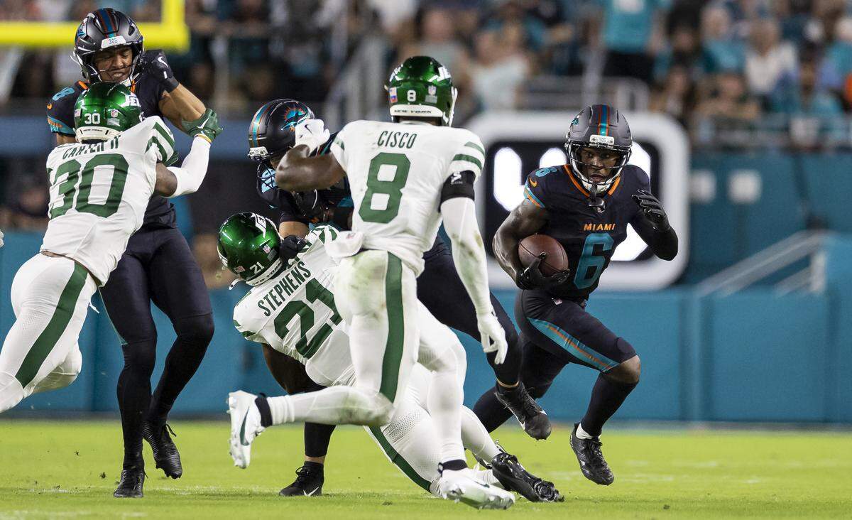 Miami Dolphins wide receiver Malik Washington (6) runs with the ball as New York Jets safety Andre Cisco (8) tries to stop him in the first half of their NFL game at Hard Rock Stadium on Monday, Sept. 29, 2025, in Miami Gardens, Fla.