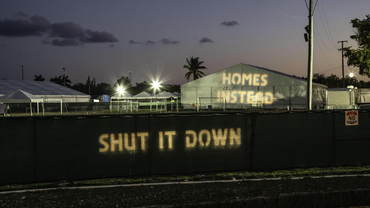 Protesters project phrases such as “Shut It Down” and “Homes Instead” from across the street at the shelter for unaccompanied minors in Homestead, FL, on Friday, March 29, 2019. The installation was created by artist/activist Alessandra Mondolfi in an effort to bring attention to the situation.