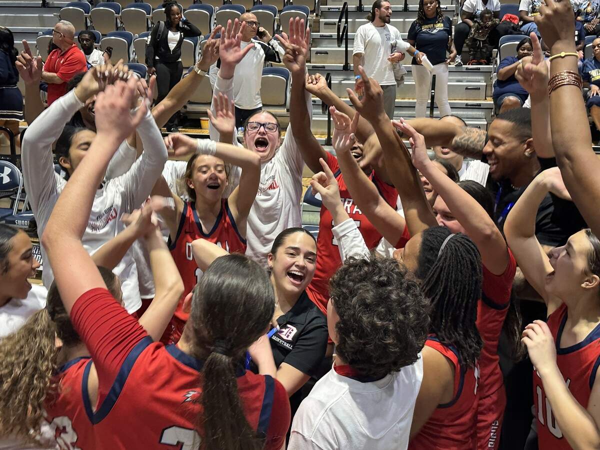 Doral Academy girls’ basketball coach Daniela Barrios (black shirt) is at the center of a wild celebration with her players and team staff after the Firebirds won their first state championship on Saturday at UNF Arena in Jacksonville, Fla.