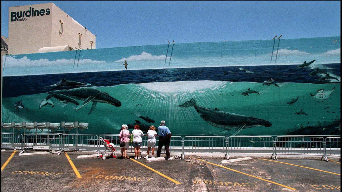 .Visitors come early to view a Marine-life mural by the artist Wyland, on the side of Burdines in downtown Miami . The seven-story, 250 foot wide mural celebrates Burdines 100th anniversary and the International Year of the Ocean.