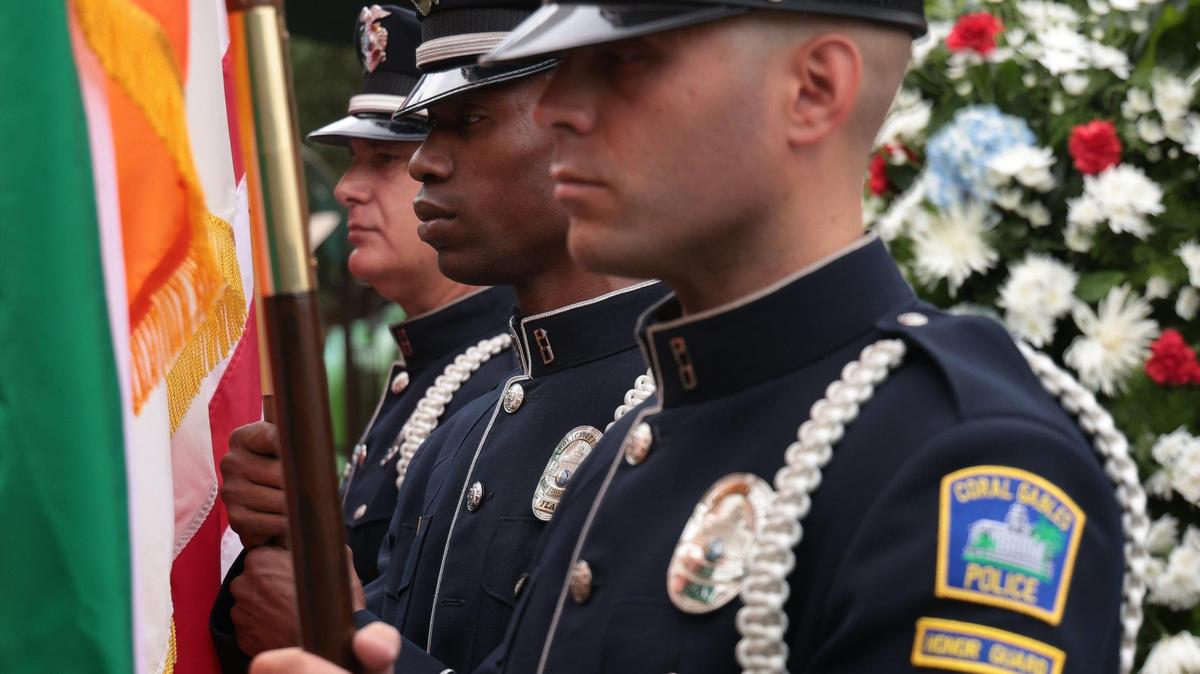 Coral Gables Honor Guard Nelson Garcia, left, Mike Clark and Gregory DiCarlo stand in remembrance of fallen Coral Gables enlisted military who fought in World War II. On Monday, May 30, 2022, residents, veterans, families and friends gathered under dark skies for the City of Coral Gables’ Memorial Day Remembrance Ceremony at the War Memorial Youth Center.