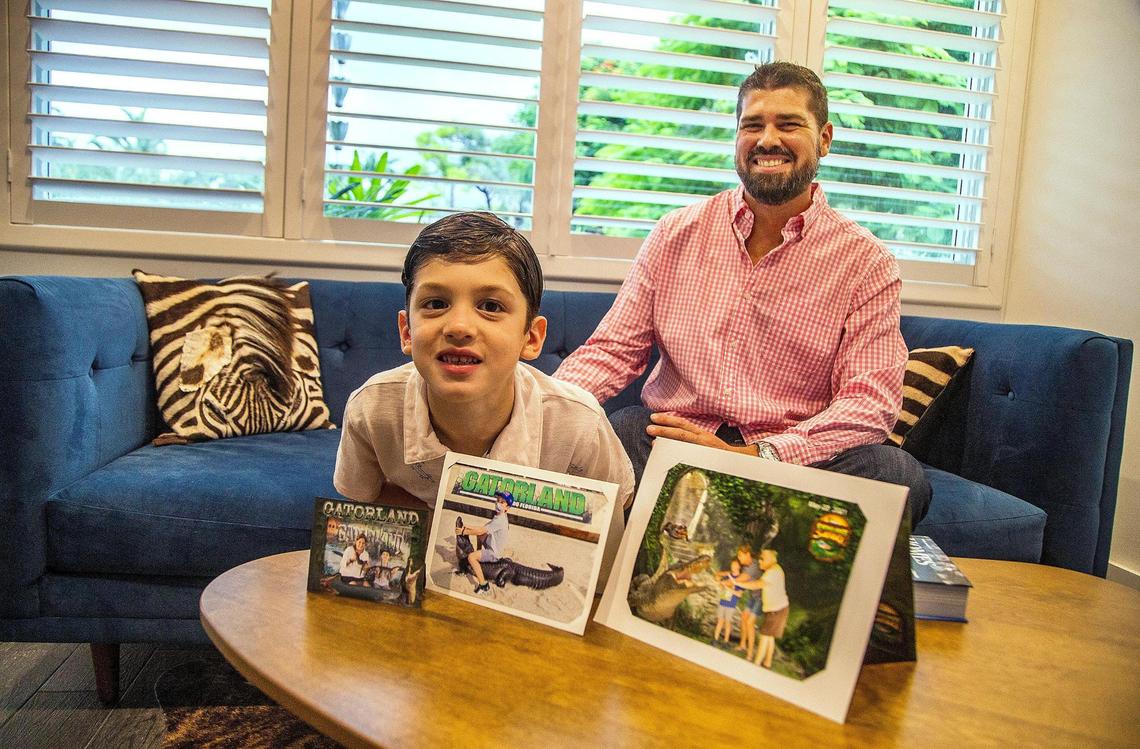 Pablo Rodriguez and his 6-year-old son, John Paul, display family pictures at their home in Miami. Pablo is the son of Elena Blasser and grandson of Elena Chavez; John Paul is the grandson and great-grandson. The two Elenas, mother and daughter, died in the Surfside condo collapse.