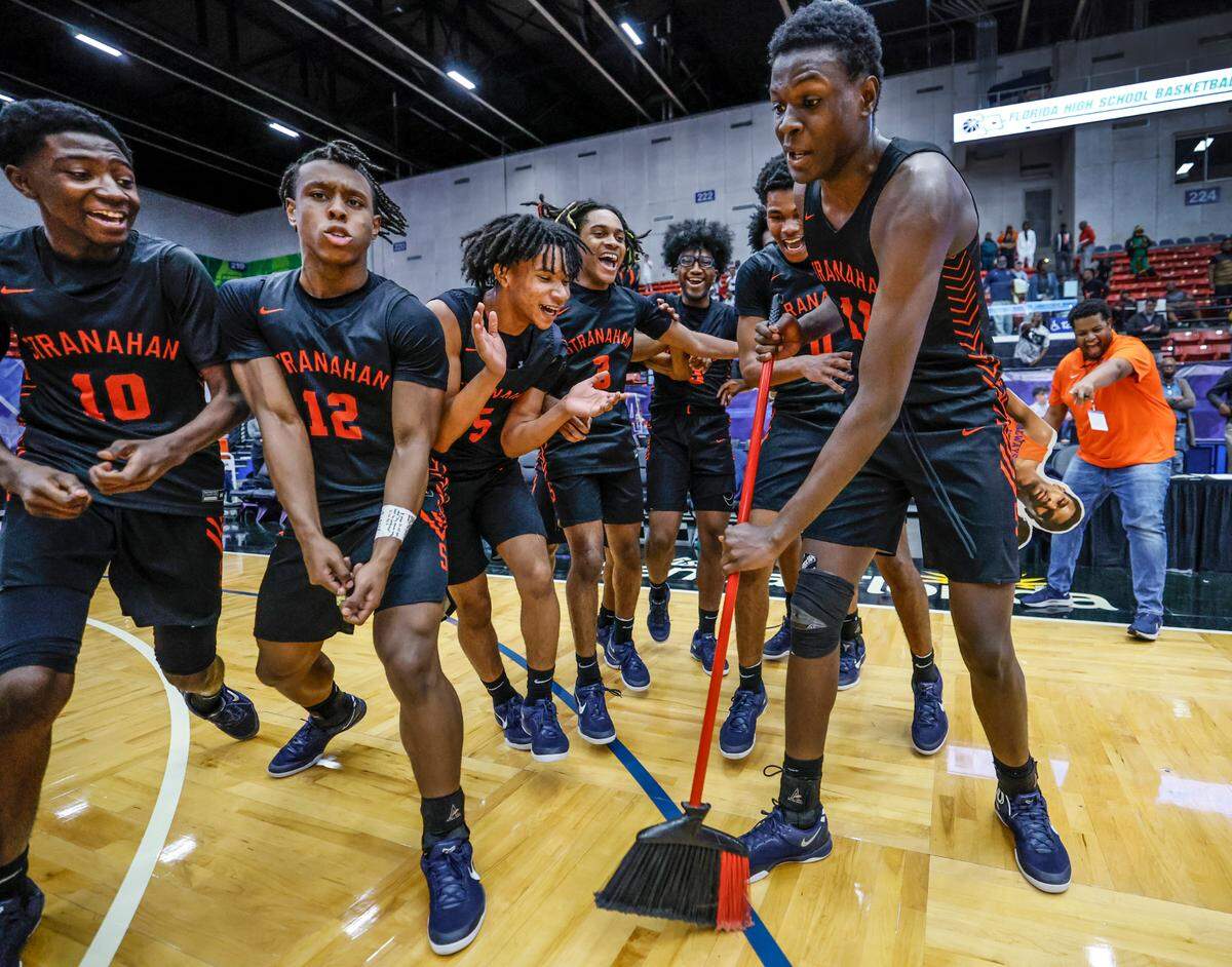 Stranahan High School’s Isaiah Brown (11) sweeps the court as the team celebrates the win over Gibbs High Schoo for the FHSAA Class 4A Boys High School Basketball State Championship