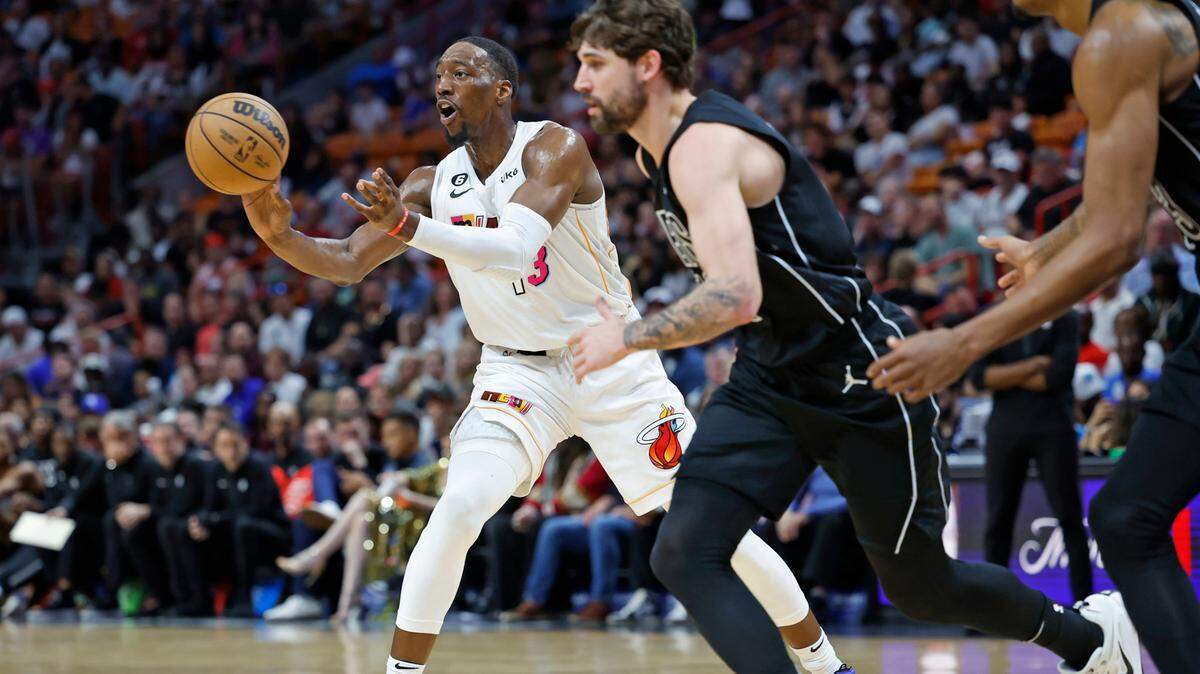 El centro del Heat Bam Adebayo (izq.) trata de pasar la pelota en el partido ante los Nets de Brooklyn, celebrado el 25 de marzo de 2023 en Miami.