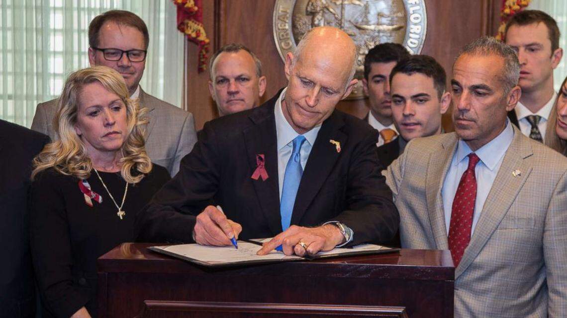 Then-Gov. Rick Scott signs into law gun and school safety legislation in March 2018, flanked by family members of those who died in the Feb. 14, 2018, Marjory Stoneman Douglas High School shooting, which killed 17 students and faculty members. State education officials met with Miami-Dade and Broward school districts on Tuesday, Aug. 30, 2022, and Thursday, Sept. 1, 2022, respectively, to review their school safety measures and discipline data they report to the state.