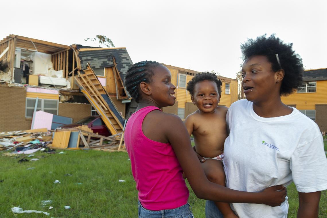 From left to right: A’Shiyah Killings, 11, Je’Zyion Smith, 1, and their mother, Tanja Graham, 29, stand outside the remains of a public housing complex unit in Panama City, Florida on Friday, October 19, 2018.