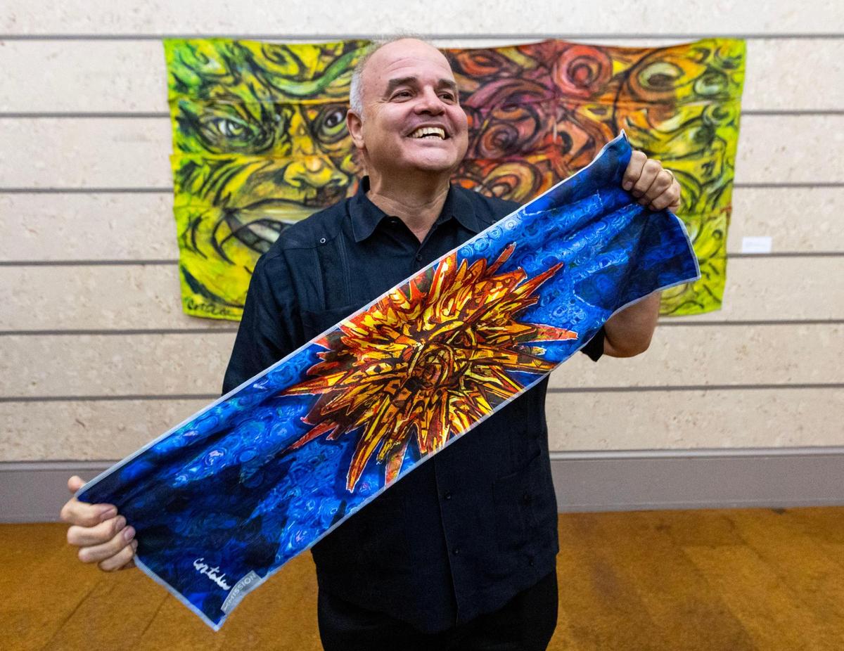 Miami-Dade artist-in-residence Xavier Cortada shows off his cooling towel designed to help people stay cool in the county’s increasing number of days of extreme heat.