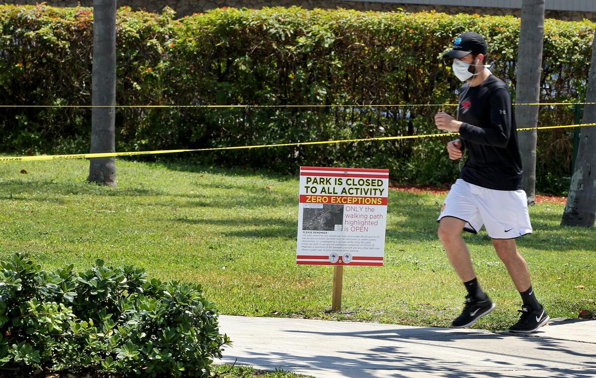 A jogger runs on the walk on April 14, 2020, as all city of Miami parks, including the Kenneth M. Myers Bayside Park in Coconut Grove, remained closed due to the coronavirus pandemic.