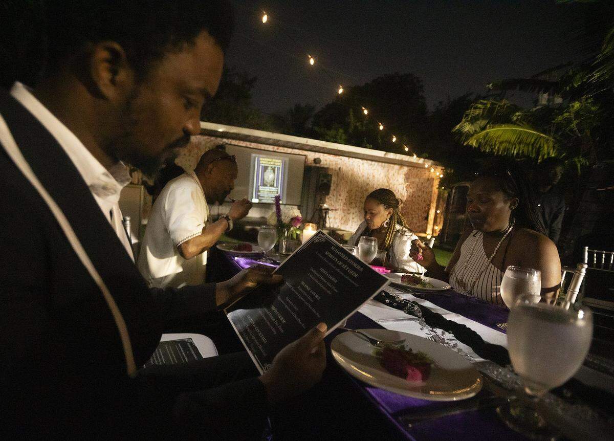 Orlando Saint Louis sits at the Fet Gede table - a Haitian Day of the Dead celebration honoring ancestors with love, music, and community, at The Vegan Marie in Little Haiti on Nov. 8, 2025.