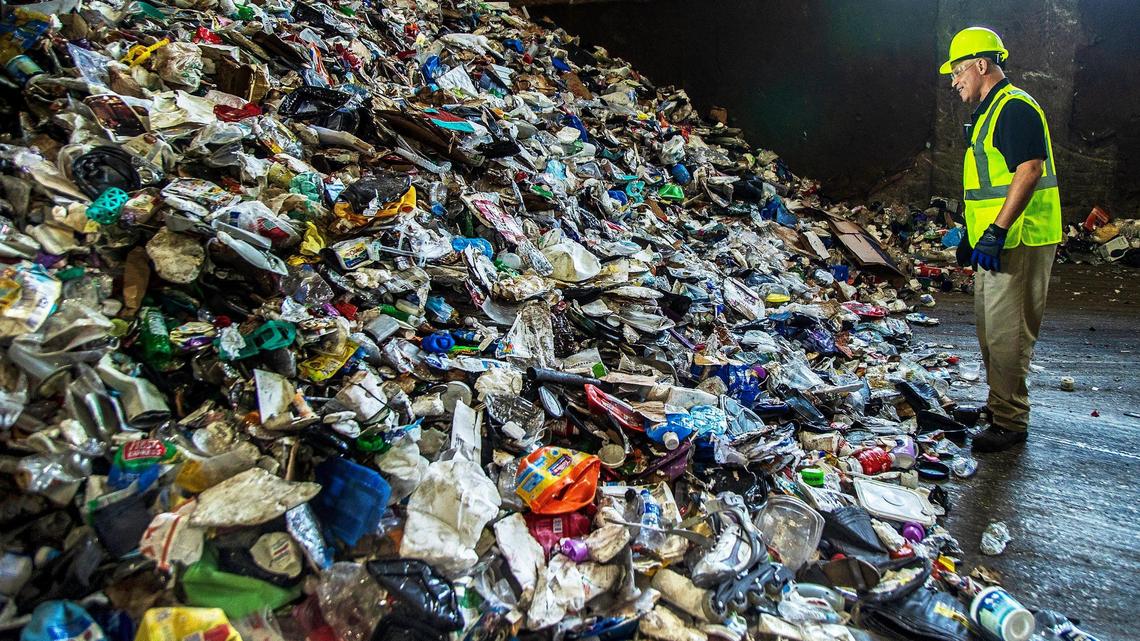 Carmelo Andino, an operations supervisor, inspects a pile of mix unsorted recycled materials, including plastic, cardboard and paper, at the Waste Management Recycling Plant in Pembroke Pines, Florida, on Friday April 8, 2022.