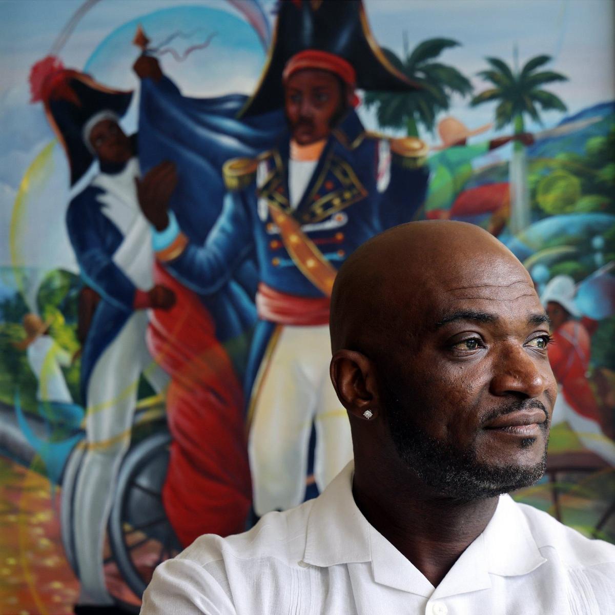 Director of the Pierre Toussaint Leadership and Learning Center, Jean A. Souffrant, reflects on the importance of the Center’s mission in America’s current political climate while standing in front of a painting of Haitian hero Toussaint L’Ouverture inside his office. Adult Haitian students attended a computer class at the Pierre Toussaint Leadership and Learning Center in the Little Haiti neighborhood of Miami, Florida, to learn digital skills and ease the pathway into employment on Wednesday, September 25, 2024.
