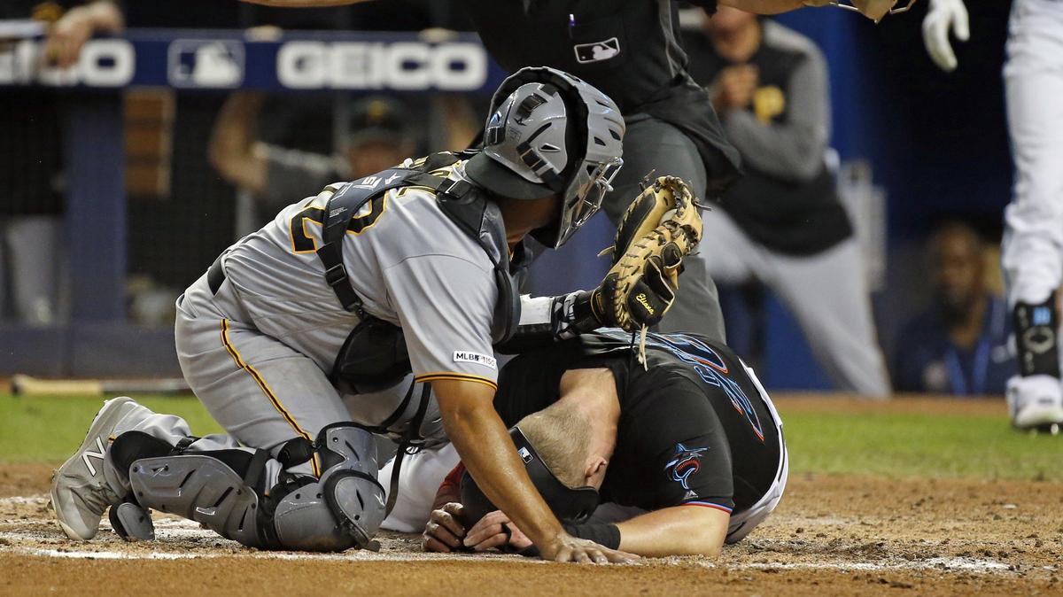 Miami Marlins left fielder Garrett Cooper (26) slides safely into home plate as Elias Diaz is late on the tag in the fourth inning as the Miami Marlins host the Pittsburgh Pirates at Marlins Park on Saturday, June 15, 2019.