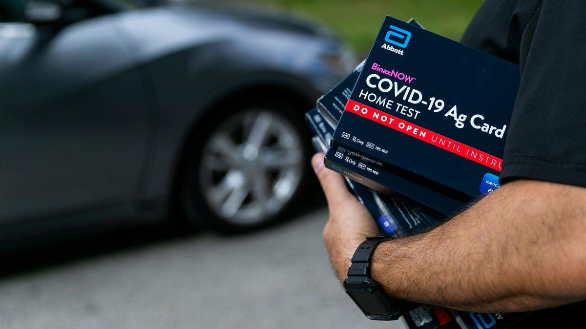Wilfredo Guilarte, a Broward County employee, hands out free at-home rapid COVID-19 tests at South Regional/Broward College Library in Pembroke Pines, Florida on Saturday, January 8, 2022.