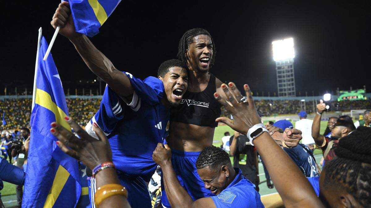 TOPSHOT - Curaçao players and fans celebrate World Cup 2026 qualification after a 0-0 draw with Jamaica at the National Stadium in Kingston, Jamaica on November 18, 2025. The tiny Caribbean nation of Curacao became the smallest country ever to qualify for the World Cup on November 18 as Haiti booked their return to the tournament for the first time in 52 years along with Panama.
A nerve-shredding finale to the CONCACAF qualifying campaign saw Curacao -- with a population of just 156,000 -- squeeze into next year's finals in the United States, Canada and Mexico with a 0-0 draw against Jamaica in Kingston. (Photo by Ricardo MAKYN / AFP) (Photo by RICARDO MAKYN/AFP via Getty Images)          