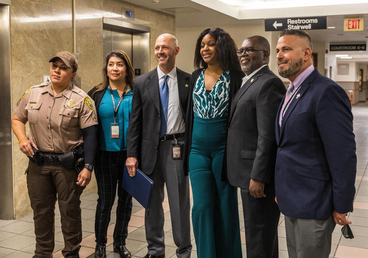 Ayanna Gordon (third from right) posed with detectives after her adopted mother Gina Emmanuel was sentenced to life in prison for murdering her 7-year-old daughter Samayah Gordon, at the Gerstein Justice Building in Miami on Wednesday, April 30, 2025.