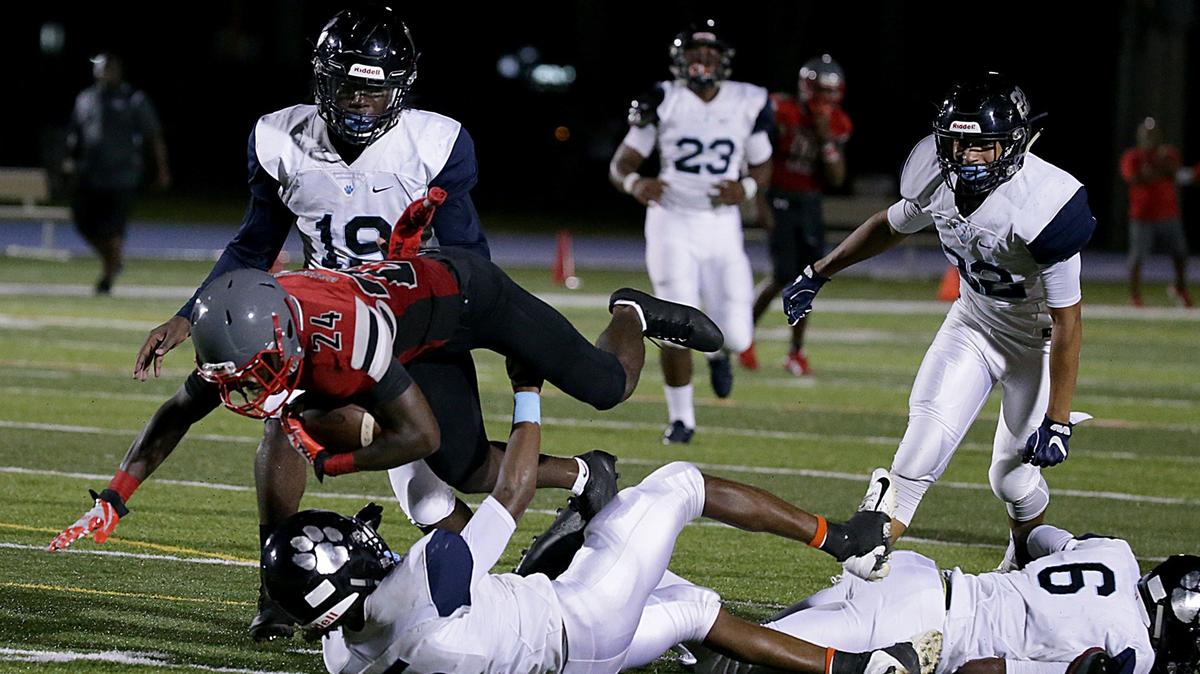 Palmetto’s Cornelius Nunn (ATH) #5 and Lorenzo Euline (DB) #6, tackled Cavaliers’ Kevoun Stewart (RB) #24, during the first quarter of the Coral Gables Cavaliers vs Miami Palmetto Varsity high school football game at Tropical Park on Thursday, September 20th, 2018.