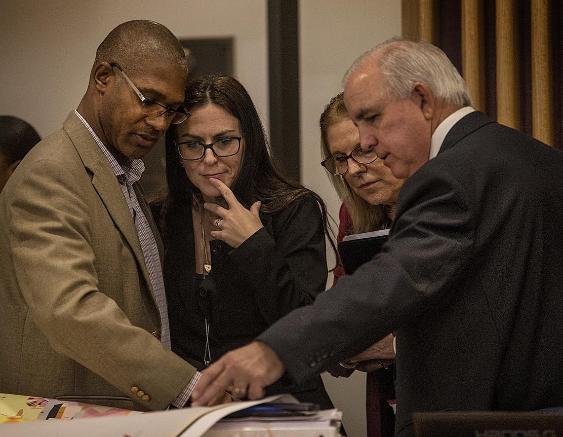 Garrett Rowe, left, and Lourdes Gomez of the planning department chat with Miami-Dade Mayor Carlos Gimenez, right, and the mayor’s senior adviser and communications director, Myriam Marquez, over a map  on Thursday, Sept. 27, 2018, at a public hearing and commission meeting to decide whether to extend State Road 836 into West Kendall.