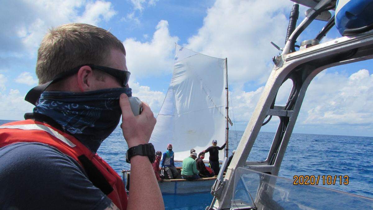 A crew member from Coast Guard cutter Isaac Mayo radios information to the ship from the small boat, Oct. 13, 2020.