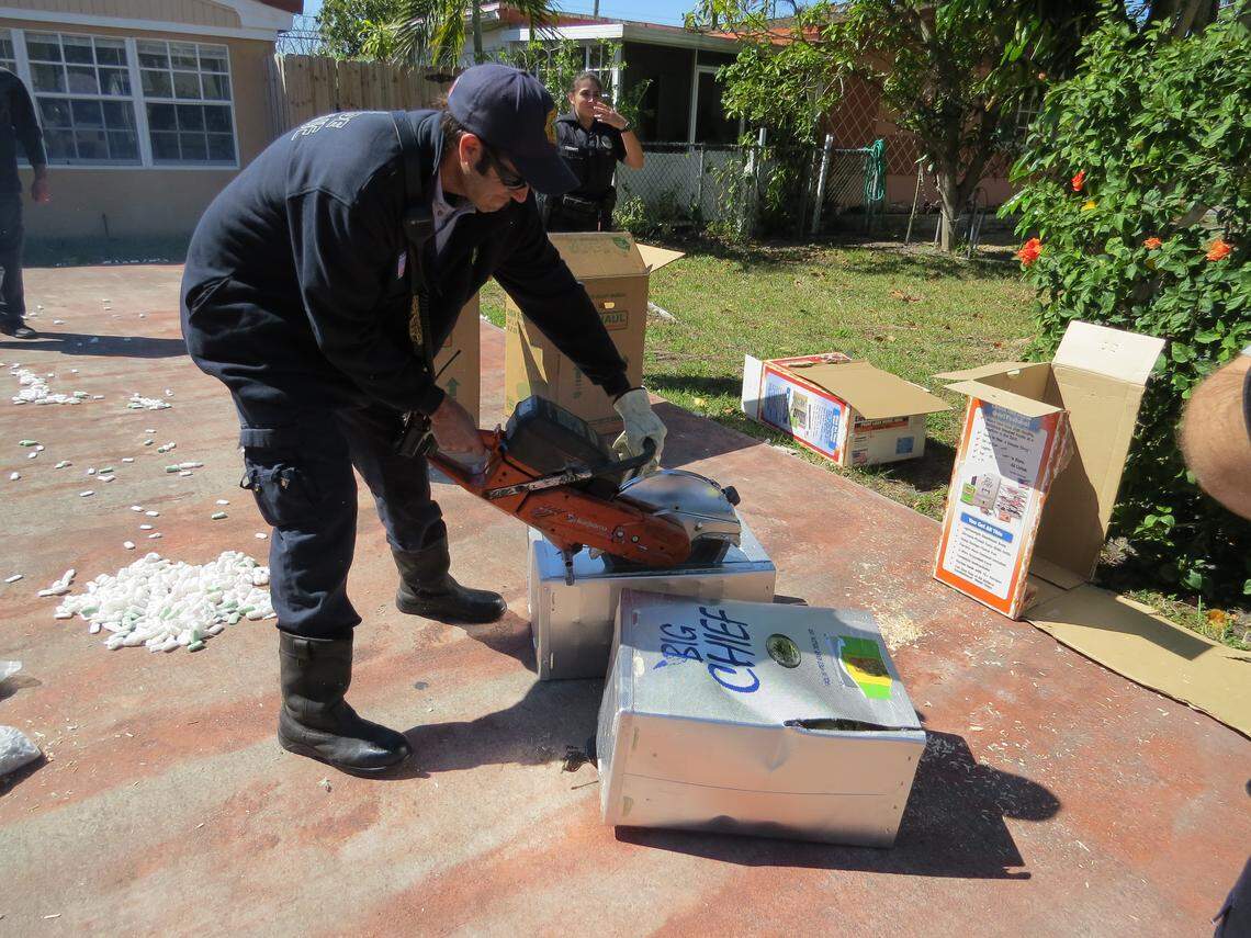 Police officers and federal agents open packages filled with marijuana seized in March 2018 at the North Miami Beach home of Yamil Cabral-Domenech.