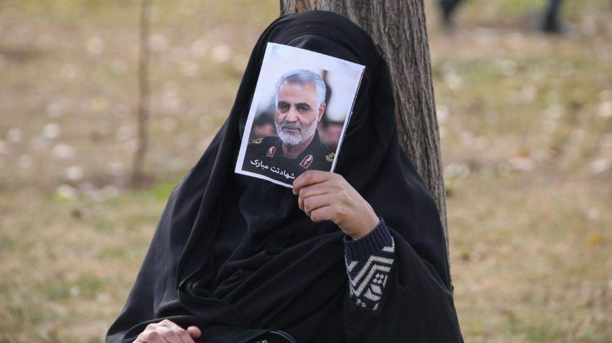 An Iranian woman holds a picture of Gen. Qassem Soleimani during a demonstration in Tehran on Jan. 3, to protest his killing in a U.S. airstrike.
