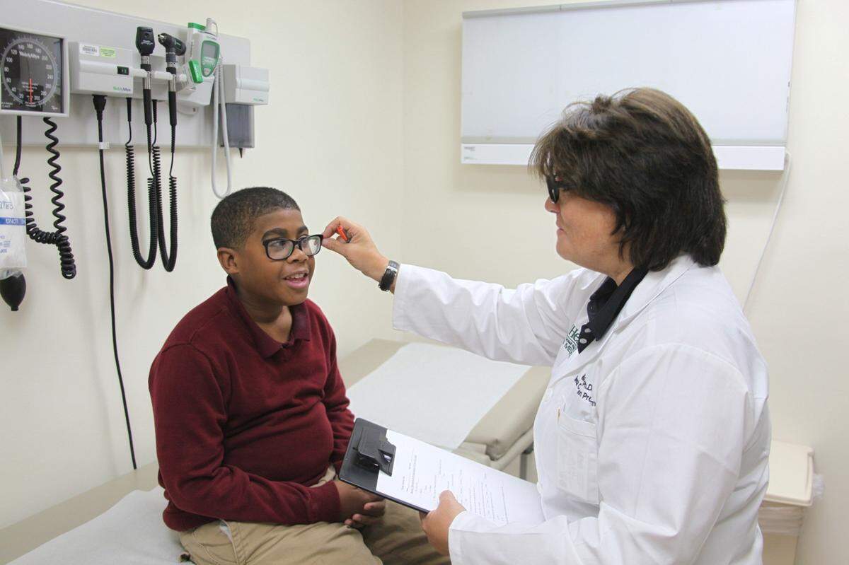 Gillian Hotz, Ph.D., examines a patient at the University of Miami’s concussion program.