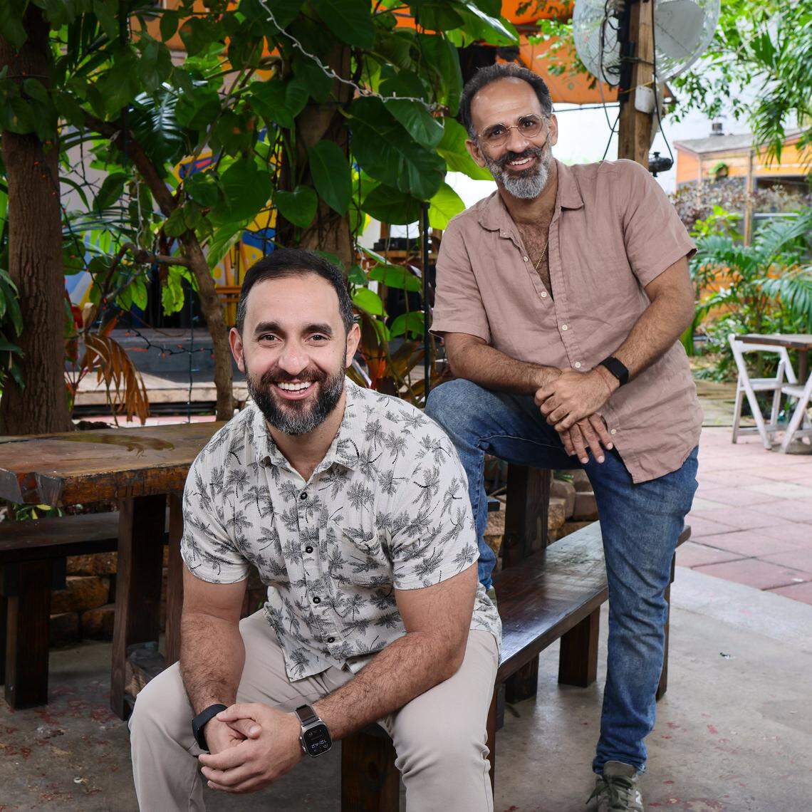Brothers Omaar, left and Noam, right, Yemini own and operate the Haitian restaurant Naomi's Garden in Little Haiti, where they were born and raised by their Israeli parents in the late 1970's. The pair is photographed in the mural-covered courtyard, which features a sound stage, on Thursday, January 15, 2026, in Miami, Florida.