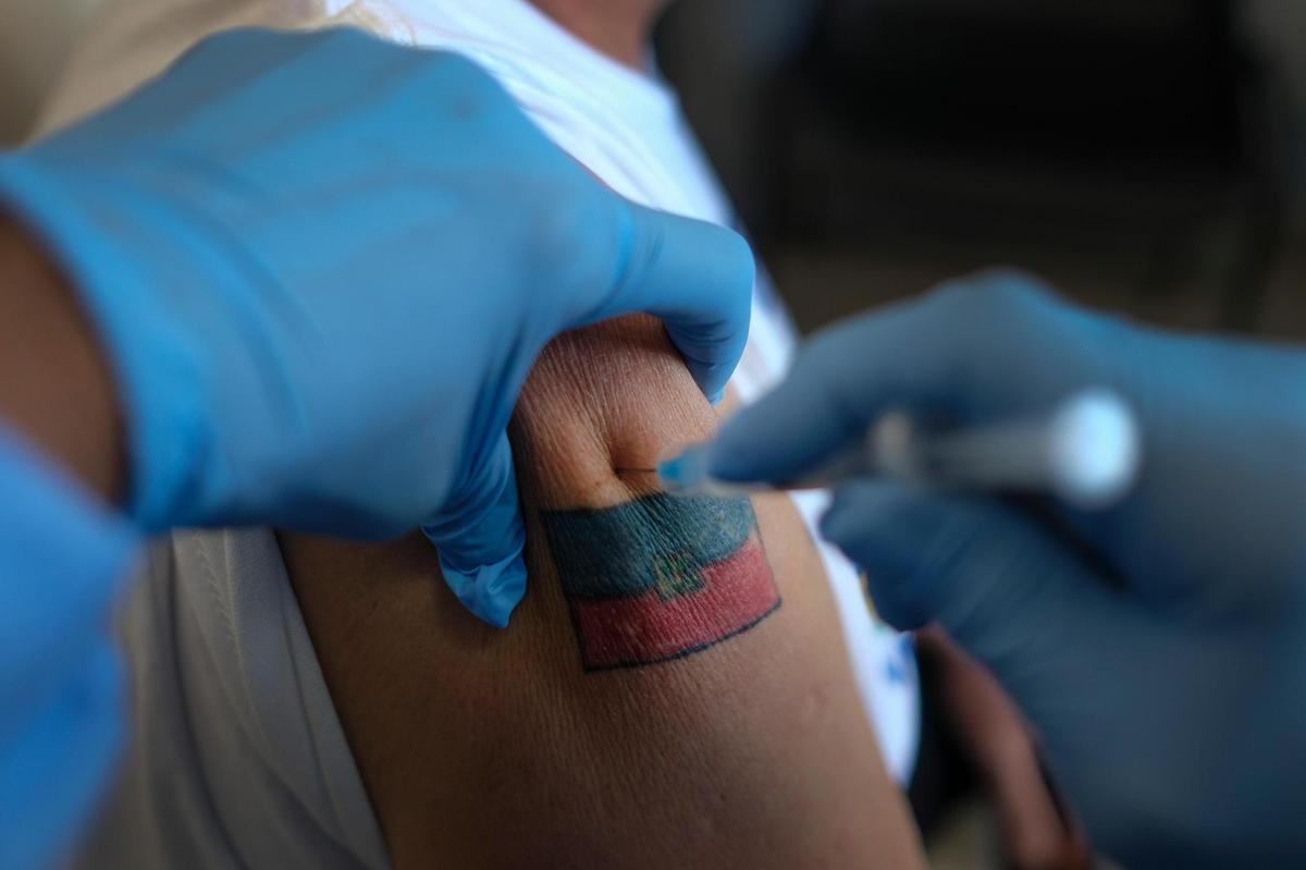 A man donning a Haitian flag tattoo is injected with his first dose of the Moderna COVID-19 vaccine at the Hospital University of Peace, in Port-au-Prince, Haiti, Saturday, July 17, 2021. Healthcare workers and senior citizens were the first people vaccinated on Friday in Haiti as part of a test run after the country recently received a shipment of doses from the United Nations.