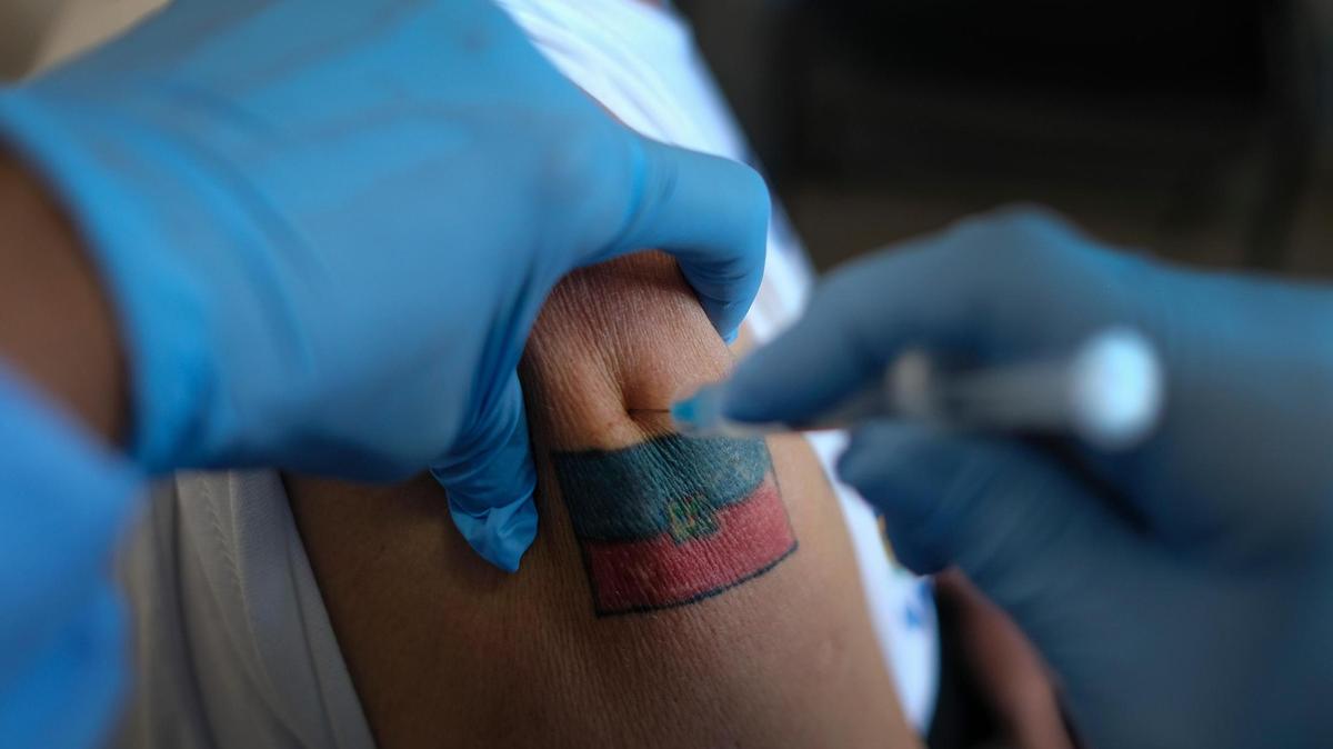 A man donning a Haitian flag tattoo is injected with his first dose of the Moderna COVID-19 vaccine at the Hospital University of Peace, in Port-au-Prince, Haiti, Saturday, July 17, 2021. Healthcare workers and senior citizens were the first people vaccinated on Friday in Haiti as part of a test run after the country recently received a shipment of doses from the United Nations.