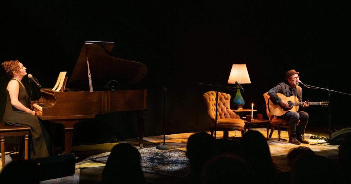 The atmosphere is that of a cozy living room for GableStage’s presentation of “Both Sides Now: The Music and Lives of Joni Mitchell and Leonard Cohen.