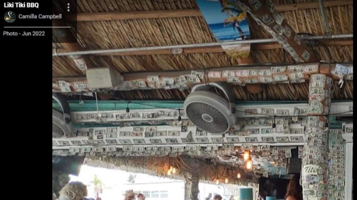 A Google Maps image of the Liki Tiki BBQ in Fort Myers Beach from June 2022, which shows dollar bills tacked to the walls, ceiling and posts at the establishment.