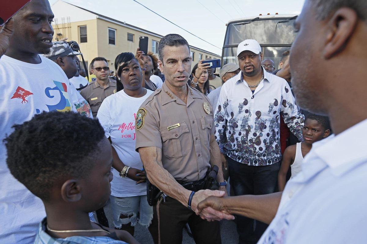Juan Perez, Miami-Dade police director, salutes Terry Elliott, founder of community nonprofit Ark of the City at a peace walk held Wednesday, April 11, 2018, following recent shootings.
