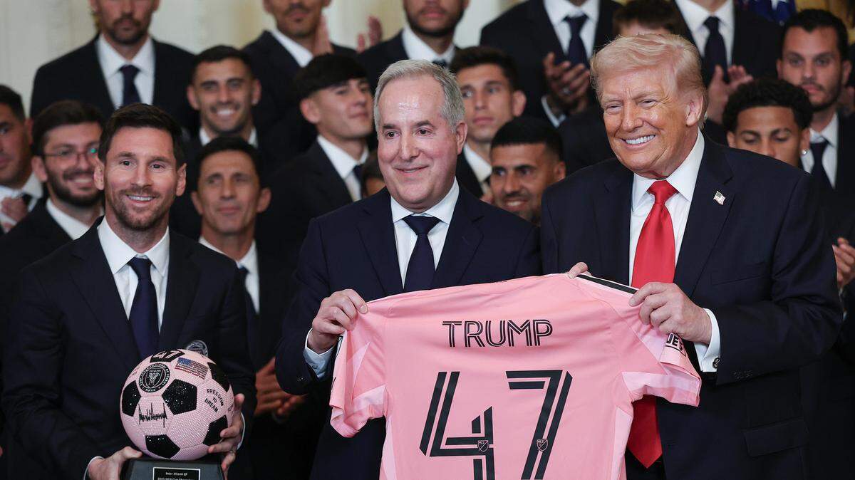 WASHINGTON, DC - MARCH 05: U.S. President Donald Trump receives gifts from Inter Miami CF CEO and Managing Owner Jorge Mas (R) as Lionel Messi (L) of Inter Miami looks on during an event celebrating the 2025 MLS Cup Champions Inter Miami CF in the East Room of the White House on March 05, 2026 in Washington, DC. Inter Miami defeated the Vancouver Whitecaps 3-1 to win their first MLS Cup championship. (Photo by Win McNamee/Getty Images)