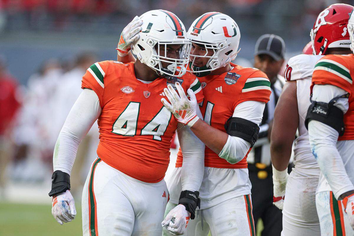 Dec 28, 2023; Bronx, NY, USA; Miami Hurricanes defensive lineman Rueben Bain Jr. (44) and linebacker Francisco Mauigoa (51) celebrates after a defensive stop during the first half of the 2023 Pinstripe Bowl against the Rutgers Scarlet Knights at Yankee Stadium. Mandatory Credit: Vincent Carchietta-USA TODAY Sports