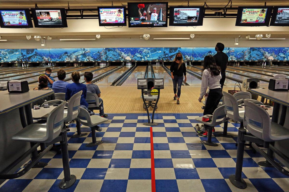 People enjoy playing bowling as they practice social distancing by leaving an empty lane at Bird Bowl Bowling Center on 9275 SW 40th St. in Westchester, Florida, as Miami-Dade County enters phase two of reopening, Saturday, September 19, 2020.