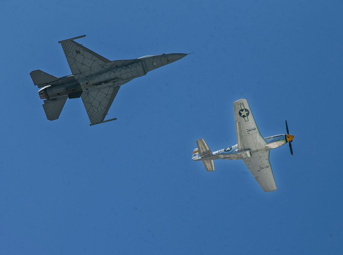 A USAF F-16 Fighting Falcon (top) and a P-51 Mustang participate in the “Heritage Fly” over South Beach during the Hyundai Air & Sea Show 2022 in Miami Beach. on Saturday May 28, 2022,