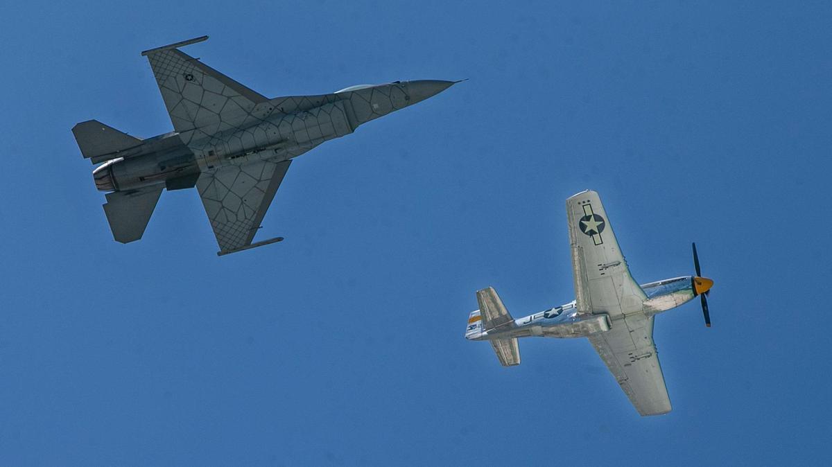 A USAF F-16 Fighting Falcon, top, and a P-51 Mustang participate in the Heritage Fly over South Beach during the Hyundai Air & Sea Show on May 28.