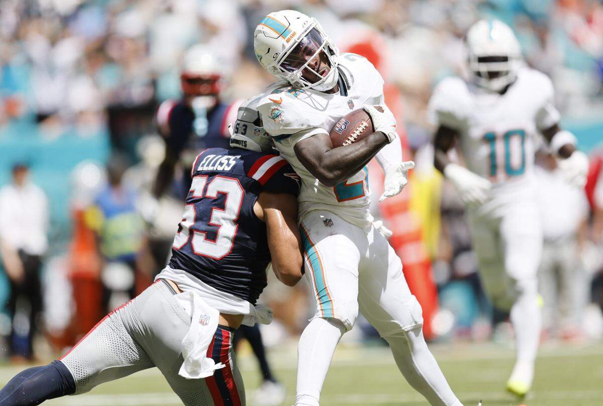 Miami Dolphins running back De'Von Achane (28)pushes his way into the endzone to score against the New England Patriots in the first half of an NFL football game at Hard Rock Stadium in Miami Gardens, Florida, on Sunday, September 14, 2025. 